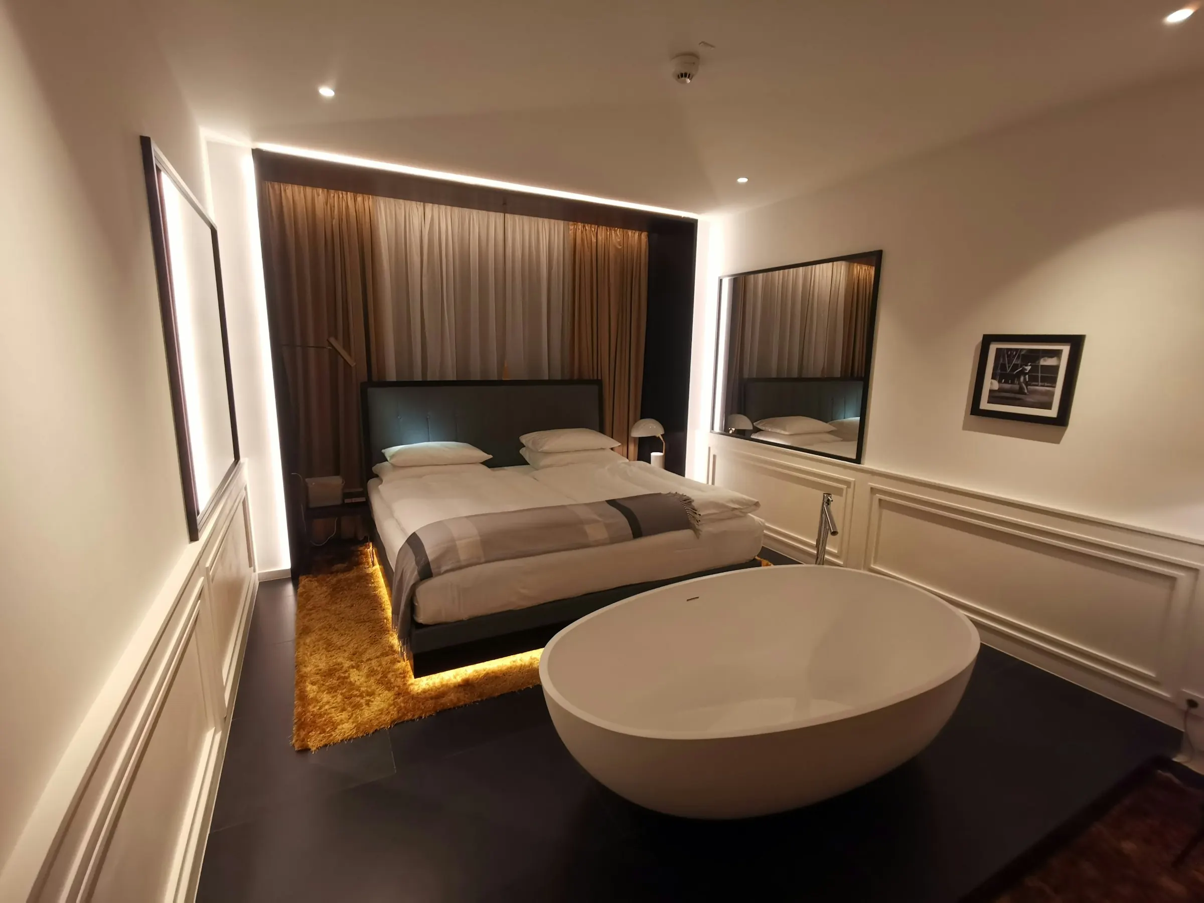 Stijlvolle design hotelkamer met warme gordijnen en vrijstaand bad